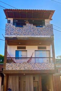 a large building with a balcony with a deck at Flats Paz in Itacaré