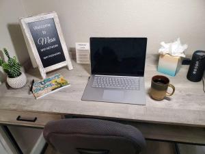a laptop computer sitting on a desk with a cup of coffee at Tranquil Mesa Retreat in Mesa