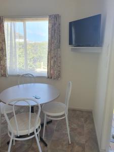 a dining room with a table and chairs and a tv at North Arm Tourist Park in Lakes Entrance