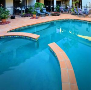 a swimming pool in a hotel with blue water at Quest Ascot in Brisbane