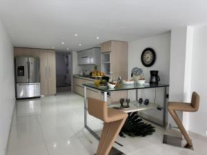 a kitchen with a table and a clock on the wall at Maca hotel cali in Cali