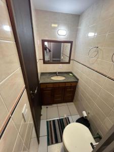a bathroom with a toilet and a sink and a mirror at Triplex White em Caiobá-Matinhos-Pr a 200 mt do mar in Matinhos +40 photos