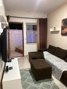 un soggiorno con un divano e un letto di Casa aconchegante no Florestinha a Cabo Frio
