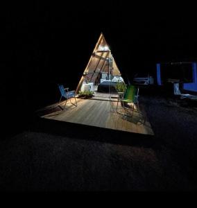 2 Stühle auf einer Holzterrasse in einem Zelt in der Unterkunft Chalé chacara dos eucaliptos in Itapecerica da Serra