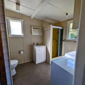 a small bathroom with a toilet and a sink at Cupie's Cabin in Talbingo