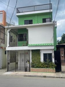 a green and white building with a gate at El Rincon de Luna in Constanza +5 photos