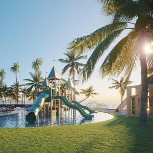 basen ze zjeżdżalnią w ośrodku z palmami w obiekcie Porto Alto Resort w mieście Cupe