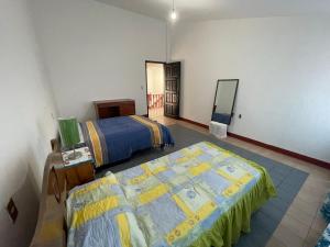 a bedroom with two beds and a table and a bed at Casa Nana , amplia y tranquila in Yelateni