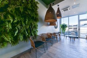 a restaurant with chairs and plants on the wall at Golden Tulip Roissy Saint Witz in Saint-Witz