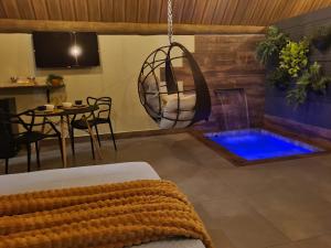 a room with a bed and a swimming pool at Chácara Kioski - Suítes e Cabanas in Brotas