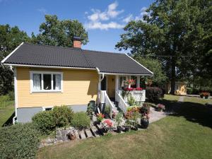 a small yellow house with flowers in a yard at Stunning Home In Strängnäs With 2 Bedrooms in Strängnäs +19 photos