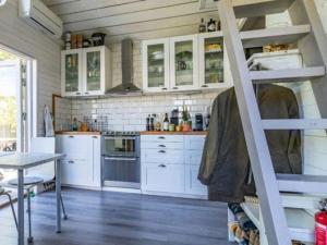 a kitchen with white cabinets and a ladder at Awesome Home In Drottningsskär With 0 Bedrooms in Drottningskär +6 photos