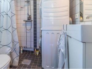 a bathroom with a white refrigerator and a toilet at Awesome Home In Drottningsskär With 0 Bedrooms in Drottningskär