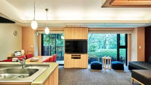 a kitchen and living room with a television and a couch at Tokyu Vacations Hakone Gora in Hakone