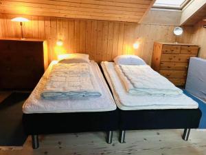 twee bedden in een kamer met houten wanden bij Amazing Home In Humble With 3 Bedrooms And Wifi in Humble +2 foto's