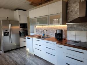 HamnedaにあるBeautiful Home In Hamneda With 4 Bedrooms And Wifiの白いキャビネットとステンレス製の冷蔵庫を備えたキッチン
