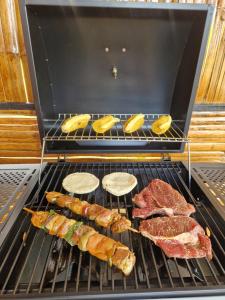 a grill with meat and other food on it at Tacuara House in San Gil
