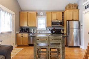 a kitchen with wooden cabinets and a stainless steel refrigerator at Seabrook 2 Bedroom cottage with hot tub, pets OK in Pacific Beach