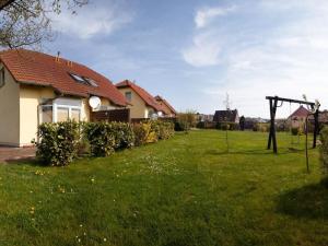 una casa con un cortile verde con una casa di Koserow Comfortable holiday residence a Ostseebad Koserow