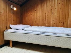 een bed in een kamer met een houten muur bij Amazing Home In Humble With 3 Bedrooms And Wifi in Humble