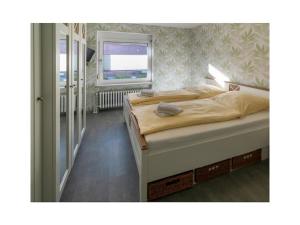 two beds in a bedroom with a window at Holiday apartment Möwenblick in Norden