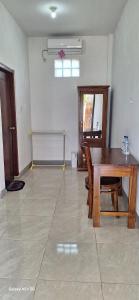 une salle à manger avec une table et des chaises en bois dans l'établissement ABC Guest House Labuan Bajo, à Labuan Bajo