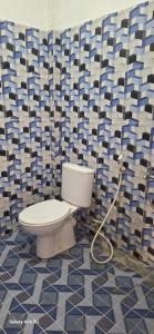 La salle de bains est pourvue de toilettes avec un tuyau. dans l'établissement ABC Guest House Labuan Bajo, à Labuan Bajo