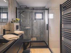 a bathroom with a shower with a glass door at Cozy Riverside Escape in Maurik