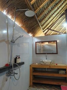 Un baño con ducha, lavabo y espejo. en Gili Air Santay Bungalows, en Gili Air