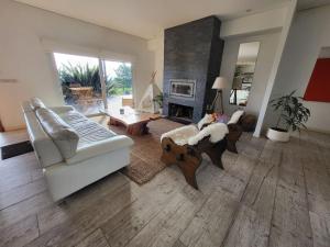 a living room with a white couch and a fireplace at Casa 5 dormitorios in Balneario Buenos Aires