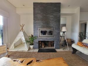 a living room with a brick fireplace with a fire place at Casa 5 dormitorios in Balneario Buenos Aires