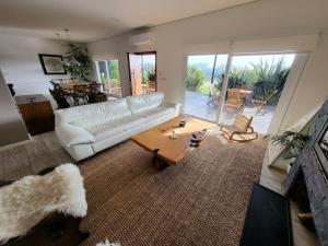 a living room with a white couch and a table at Casa 5 dormitorios in Balneario Buenos Aires