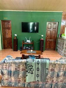 a living room with a couch and a green wall at The kiwi house BRASSO SECO VILLAGE in Brasso Seco Village