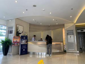 un homme debout à un comptoir dans un magasin dans l'établissement Netflix & Chill at Pablo's Homestay-Grace Residences Tower 4, à Manille