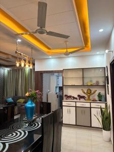 a living room with a table and a kitchen at ANAisha mansION Near Helipad Rajpur Road shastradhara Hill View in Dehradun