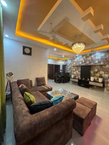 a living room with two couches and a tv at ANAisha mansION Near Helipad Rajpur Road shastradhara Hill View in Dehradun