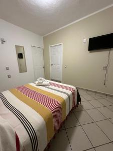 una camera con un letto con una coperta a righe di Casa Eva a Tepoztlán
