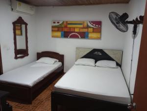 una stanza con due letti e un dipinto sul muro di Hotel Bethesda 316 a 822 a 1980 a Aguachica