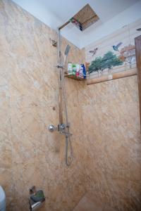 Un baño con ducha y cabezal de ducha en Sleeperwood Villa, en Unawatuna