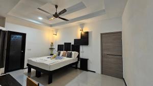 Cette chambre comprend un lit et un ventilateur de plafond. dans l'établissement Crown Beach Family villas, à Dhiffushi
