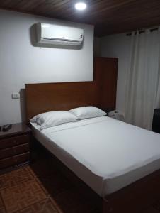 una camera da letto con un letto e un condizionatore a muro di Hotel Bethesda 316 a 822 a 1980 a Aguachica