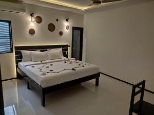 une chambre avec un lit avec des draps blancs et des oreillers dans l'établissement Crown Beach Family villas, à Dhiffushi
