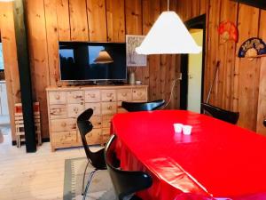 een rode tafel en stoelen in een kamer met een televisie bij Amazing Home In Humble With 3 Bedrooms And Wifi in Humble