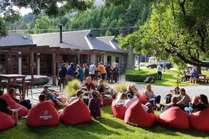 フランクトンにあるQueenstown Luxury Holiday Villaの芝生の上の赤い豆袋に座っている人々のグループ