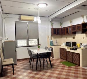 a kitchen with a table and chairs in a room at 97 Light House Songkhla in Songkhla