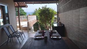 a wooden table and chairs on a patio at Casa na Praia Araçá in Bombas