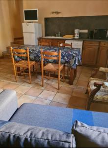 Una cocina con una mesa con sillas y un refrigerador. en Hameau De Cure, en Cazouls-lès-Béziers 4 fotos más