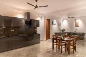 a living room with a table and a kitchen at The Wispring Pine Kasauli 7o1827o7o3 in Kasauli