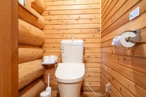 a bathroom with a toilet and wooden walls at S-villa Karuizawa Muguet in Hoshina