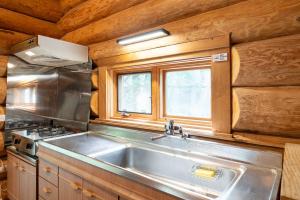 a kitchen with a stainless steel sink and a window at S-villa Karuizawa Muguet in Hoshina